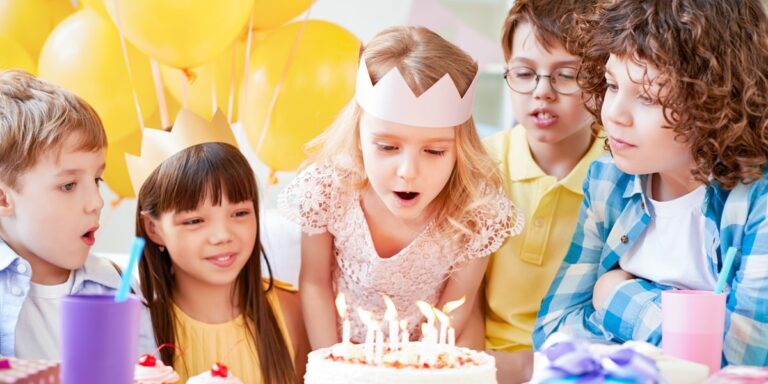 Kinder feiern gemeinsam einen Geburtstag mit Geburtstagskuchen, Kerzen, Luftballons und bunten Partydekorationen im Monki Park.